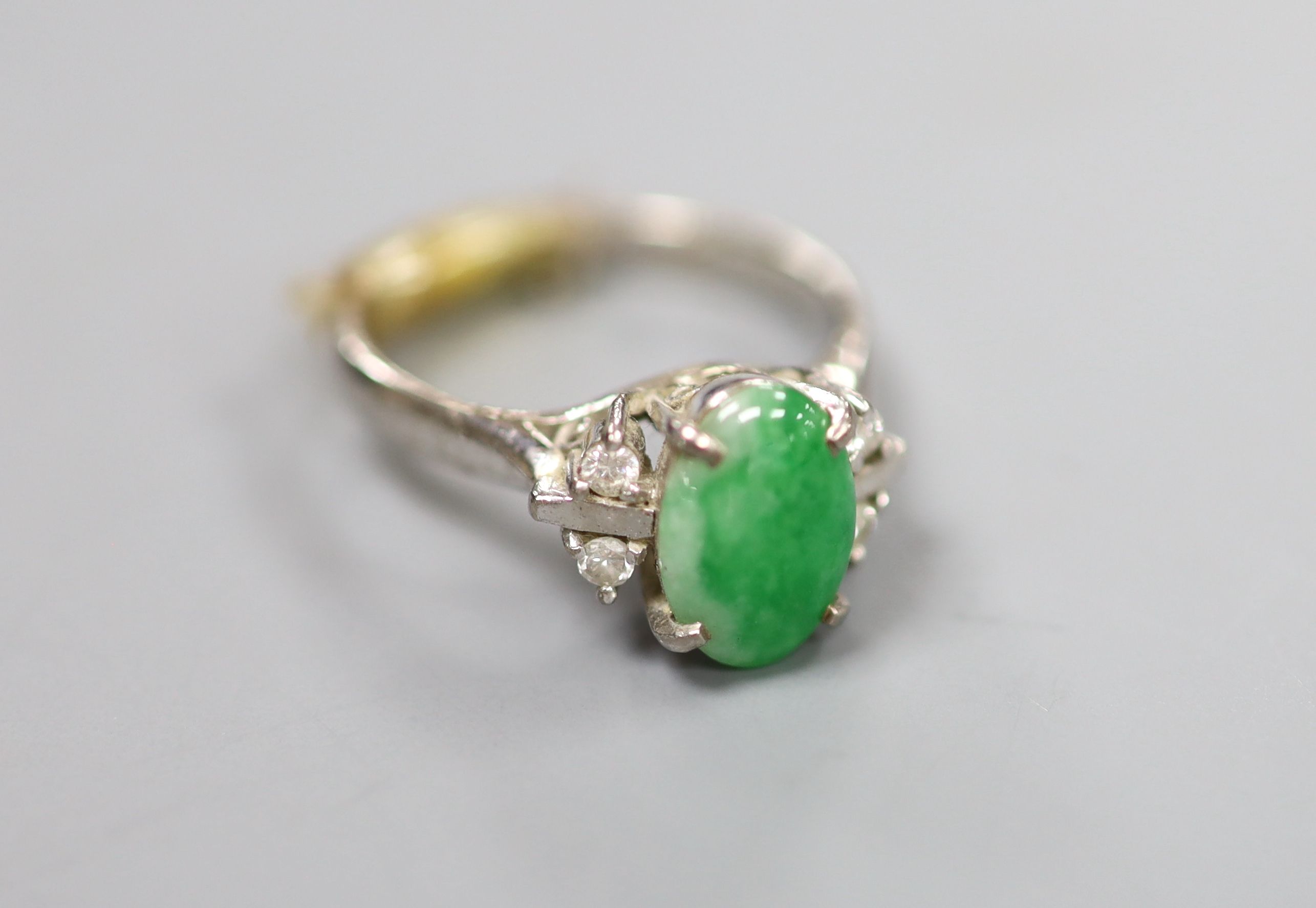 A 20th century 585 white metal, cabochon jade and diamond set five stone ring, size H/I, gross 3.6 grams.